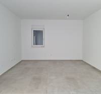 An empty room in a 4-room apartment with tiles and a window.