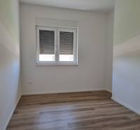 A room with a wooden floor and a window in a 4-room apartment.