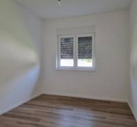 Empty room with wooden floor and a window, 3-room apartment.
