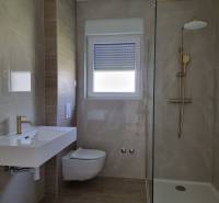 A bathroom in a 3-room apartment with a sink, toilet, and shower.
