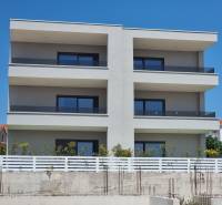 An apartment building in the city of Vodice with three floors and glass balconies.