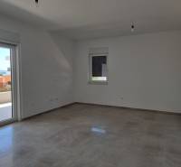 A spacious room of a 4-room apartment with a view to the outside through the balcony doors.