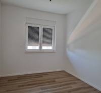 Interior of a 4-room apartment with white walls and wooden flooring.