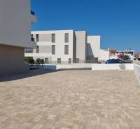 Parking lot at a 4-room apartment in the city of Vodice with a paved surface and clean architecture.