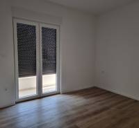 A room with drawn blinds and floating floor in a 4-room apartment.
