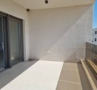 Balcony of a 4-room apartment in Vodice with glass railings and sliding doors.