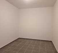 Empty room with gray tiles in a 4-room apartment.