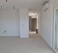 Spacious interior of a 4-room apartment with white walls and air conditioning.