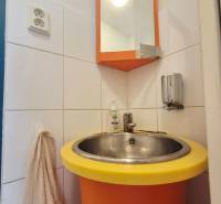 Orange sink with a round yellow rim, mirror, and towel rack.