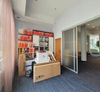 Office space with filing cabinets and packages in the office, illuminated by large windows.
