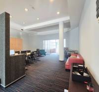 Commercial space with a conference table, red sofa, and modern furniture.