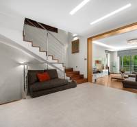 Interior of a family house with a sofa, staircase, and spacious living room with a terrace.