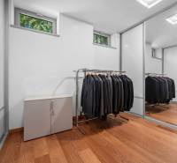 A wardrobe in a family house with a mirrored closet and clothes hangers.