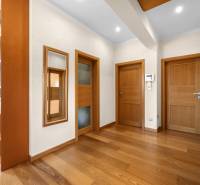 Hallway of a family house with wooden doors and a shelving system.