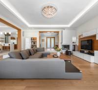 Living room in a family house with a large gray couch and white furniture.