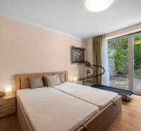 Bedroom in a family house with a double bed, treadmill, and garden view.