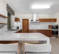 A kitchen in a family house with built-in appliances and wooden kitchen cabinets.