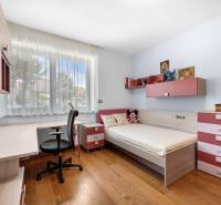 Children's room in a family house with a bed, a desk, and decorations.