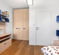 A children's room in a family house with wooden floors and shelves full of books.