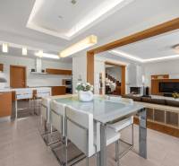 Interior of a family house with a dining table, kitchenette, living room, and staircase.