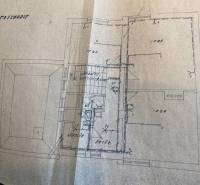 Floor plan of a family house with rooms and staircase. Warm paper tones.