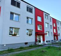 A block of flats in the housing estate in Jablonica with a gray facade and red elements.