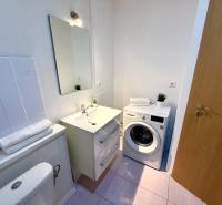 Bathroom in a 2-room apartment with a mirror, washing machine, and toilet.
