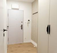 Bright hallway in a 2-room apartment with wooden flooring and white walls.