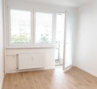 In the 2-room apartment, there is a bright room with balcony doors and a wooden floor.
