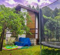 A cottage in Mojš surrounded by greenery, a garden with a trampoline, and a unique atmosphere.