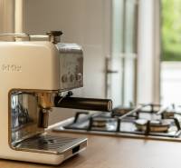 Coffee maker kMix and gas stove on the kitchen counter in a 2-room apartment.