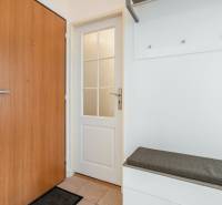 White interior with doors and a bench in a 2-room apartment.