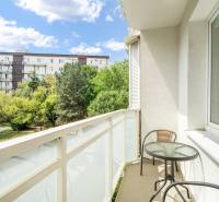 The balcony of the 2-room apartment offers a view of greenery and residential buildings in Bratislava.