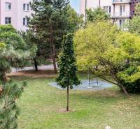 Park in Bratislava on Czechoslovak Paratroopers with a bench and greenery, surrounded by apartment buildings.
