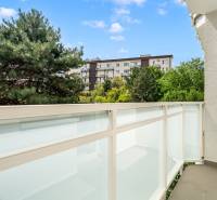 A balcony with a view of greenery and residential buildings in Bratislava - Nové Mesto.