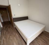 Bedroom in a 2-room apartment with a bed and wooden floor, the door leads to the hallway.