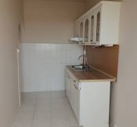 A kitchen with white cabinets and a sink in a 3-room apartment.