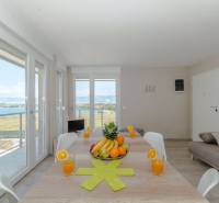 Recreational apartment with a large table, sea view, fruit, and glasses of juice.