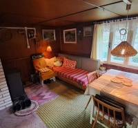 Rustic cottage furnishings with a fireplace, dining table, and sofa.