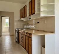 A kitchen in a 3-room apartment with wooden cabinets and a stove.