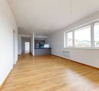 Spacious living area with wooden flooring in a 3-room apartment.