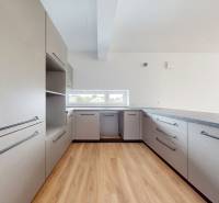 A kitchen in a 3-room apartment with light cabinets and wooden floors.