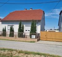 Family house on Písniky Street in Malacky, white facade, red roof, thuja trees by the fence.