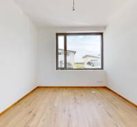 Empty room with wooden floor and large window in a family house.