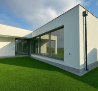 A family house in Kostolište on Martina Benka Street with large glass windows and a lawn.