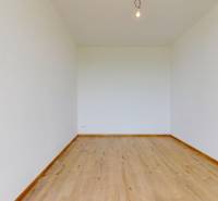 White wall, wooden floor in a family house, simple lighting with a light bulb.