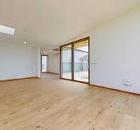A spacious room with large windows and wooden flooring in a family house.