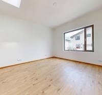 An empty bright room with a wooden floor and a large window in a family house.