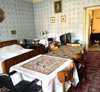 Interior of a family house with a bed, table, and television, a space with traditional decorations.