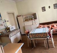 Kitchen in a family house with a dining table, microwave, and sofa.